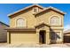 Inviting tan two-story home featuring arched windows, a tile roof, and a front-facing two-car garage at 2546 E Camellia Dr, Gilbert, AZ 85296