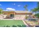 This backyard has a covered patio, an artificial lawn, palm trees, and raised garden beds, providing an inviting outdoor space at 2560 S Rowen --, Mesa, AZ 85209