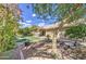 A backyard with an artificial lawn, raised garden beds, trees, a covered patio with table and chairs, all under a blue sky at 2560 S Rowen --, Mesa, AZ 85209