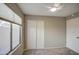 This bedroom features neutral walls, carpet, a ceiling fan, closet, a window with blinds, and a white door at 2560 S Rowen --, Mesa, AZ 85209