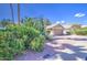 Well-maintained home with desert landscaping featuring flowering bushes, a two-car garage, and a wide driveway at 2560 S Rowen --, Mesa, AZ 85209