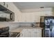 Well-equipped kitchen featuring granite countertops, white cabinetry, and modern black appliances at 2560 S Rowen --, Mesa, AZ 85209