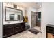 Well-lit bathroom features double sinks, vanity, and tiled walk-in shower with neutral earth tone at 2678 S 172Nd Dr, Goodyear, AZ 85338