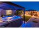 Backyard hot tub under covered patio with outdoor kitchen and bar area and artificial turf at 2678 S 172Nd Dr, Goodyear, AZ 85338
