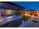 Backyard hot tub under covered patio with outdoor kitchen and bar area and artificial turf at 2678 S 172Nd Dr, Goodyear, AZ 85338