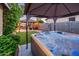 Backyard hot tub under a covered patio with an outdoor kitchen and seating area at 2678 S 172Nd Dr, Goodyear, AZ 85338