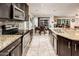 Bright kitchen featuring dark cabinetry, granite countertops, stainless appliances, and open dining area at 2678 S 172Nd Dr, Goodyear, AZ 85338