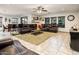 Spacious living room with tile floors, ceiling fan, comfortable leather seating, and natural light at 2678 S 172Nd Dr, Goodyear, AZ 85338