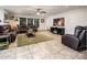 Comfortable living room with tile floors, leather sectional, TV and access to dining area at 2678 S 172Nd Dr, Goodyear, AZ 85338