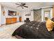 Spacious main bedroom featuring tile flooring, a ceiling fan, barn door to bathroom, and dresser at 2678 S 172Nd Dr, Goodyear, AZ 85338