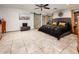 Serene main bedroom featuring tile flooring, a ceiling fan, and a stylish barn door to the bathroom at 2678 S 172Nd Dr, Goodyear, AZ 85338