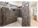 Nicely tiled walk-in shower features a built-in bench and overhead shower with neutral earth tones at 2678 S 172Nd Dr, Goodyear, AZ 85338