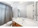 Neutral bathroom featuring a large mirror, wooden vanity, white sink, and shower with gray curtain at 2741 E Bridgeport Pkwy, Gilbert, AZ 85295