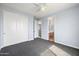 Cozy bedroom featuring gray carpeting, a ceiling fan, and a well-lit view into the bathroom for added convenience at 2741 E Bridgeport Pkwy, Gilbert, AZ 85295