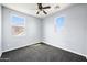 A carpeted bedroom with two windows providing natural light and a ceiling fan at 2741 E Bridgeport Pkwy, Gilbert, AZ 85295