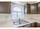 A kitchen features stainless steel sink, pink countertops, and medium-toned wood cabinets at 3001 E Amber Ridge Way, Phoenix, AZ 85048