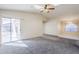 Open living room with carpet, a ceiling fan, a skylight, and sliding glass door to patio at 3001 E Amber Ridge Way, Phoenix, AZ 85048