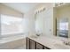 Main bathroom features a double vanity, a large tub and white tile floors at 3001 E Amber Ridge Way, Phoenix, AZ 85048