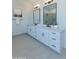 Well-lit bathroom with a double vanity, modern fixtures, and a decorative mirror at 33417 N 142Nd Way, Scottsdale, AZ 85252