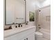 Well-lit bathroom features a modern vanity with a white countertop, matte black faucet, and a shower with neutral tile at 33417 N 142Nd Way, Scottsdale, AZ 85252