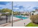 Community pool area with lounge chairs and umbrellas, surrounded by a secure fence at 3823 N 28Th St, Phoenix, AZ 85016