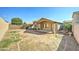 Expansive backyard with potential for landscaping and recreation with brick-lined borders, covered patio, and block fence at 4050 E Agave Rd, Phoenix, AZ 85044