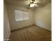 This bedroom features neutral carpet, a ceiling fan, and a window with blinds at 4050 E Agave Rd, Phoenix, AZ 85044