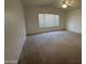 This bedroom features neutral carpet, a ceiling fan, and a window with blinds at 4050 E Agave Rd, Phoenix, AZ 85044