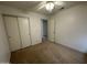 This bedroom includes carpet, a ceiling fan, and a closet with sliding doors at 4050 E Agave Rd, Phoenix, AZ 85044