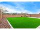 Spacious backyard with artificial turf, decorative rock and a view of neighboring houses at 4135 E Sagebrush St, Gilbert, AZ 85296