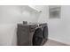 Modern laundry room featuring a gray Samsung washer and dryer set with shelving and natural light at 4135 E Sagebrush St, Gilbert, AZ 85296