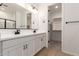 Modern bathroom with dual sinks and a walk-in closet at 5352 W Las Palmaritas Dr, Glendale, AZ 85302