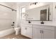 Bright bathroom with double vanity, black hardware, tub, and window at 5352 W Las Palmaritas Dr, Glendale, AZ 85302