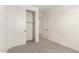 A bedroom with light walls and carpet along with a closet and door at 5352 W Las Palmaritas Dr, Glendale, AZ 85302