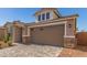 Attached two-car garage showcasing stone veneer accents and a paved driveway for added curb appeal at 5352 W Las Palmaritas Dr, Glendale, AZ 85302