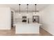 Bright kitchen features a large island, stainless steel appliances, white cabinets, and pendant lighting at 5352 W Las Palmaritas Dr, Glendale, AZ 85302
