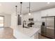 Modern kitchen with stainless steel appliances, a center island, white cabinets, and pendant lighting at 5352 W Las Palmaritas Dr, Glendale, AZ 85302