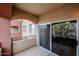 View of a covered balcony with a glass sliding door and decorative concrete arches at 5401 E Van Buren St # 2095, Phoenix, AZ 85008