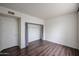 A bedroom featuring light walls, wood flooring, a closet with curtains, and bright light at 5401 E Van Buren St # 2095, Phoenix, AZ 85008