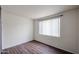 A neutral bedroom with wood-look flooring, bright white walls, and a window ready for new decor at 5401 E Van Buren St # 2095, Phoenix, AZ 85008