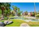 Beautiful community pond with tropical landscaping, fountain, and surrounding condo buildings in a lush neighborhood at 5401 E Van Buren St # 2095, Phoenix, AZ 85008