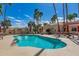 Community pool with inviting blue water surrounded by palm trees, seating, and umbrellas at 5402 E Mckellips Rd # 326, Mesa, AZ 85215