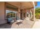 Cozy covered back patio with stone flooring, comfortable seating, and bright, natural light at 5929 W Riviera Dr, Glendale, AZ 85304