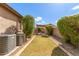 Well-maintained backyard with grass, stone landscaping, and shaded pergola seating area at 5929 W Riviera Dr, Glendale, AZ 85304