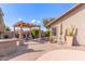 Spacious backyard featuring a built-in grill, pergola, seating area, and desert landscaping at 5929 W Riviera Dr, Glendale, AZ 85304