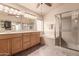 Well-lit bathroom featuring a double sink vanity, a bathtub, and a shower with a glass enclosure at 5929 W Riviera Dr, Glendale, AZ 85304