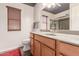 Bathroom with wooden cabinets, a toilet and a window with wooden blinds at 5929 W Riviera Dr, Glendale, AZ 85304