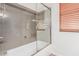 Well-lit bathroom features a shower and bathtub combination with a sliding glass door at 5929 W Riviera Dr, Glendale, AZ 85304