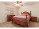 Cozy bedroom features a ceiling fan and traditional furniture in a neutral color palette at 5929 W Riviera Dr, Glendale, AZ 85304