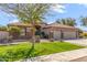 Charming single-story home showcasing a well-manicured lawn, desert landscaping, and a spacious three-car garage at 5929 W Riviera Dr, Glendale, AZ 85304